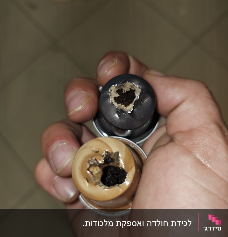 קפסולות קפה עם חורים ביד אדם